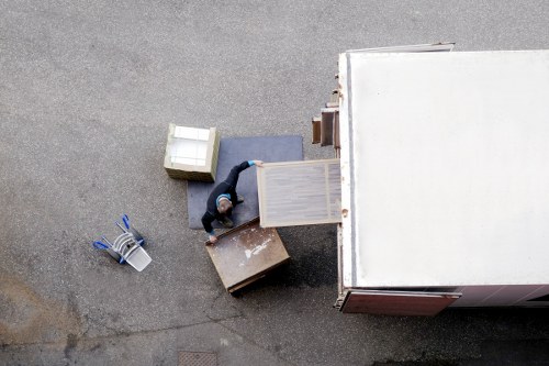 Volunteers loading donated furniture into charity van at transfer station